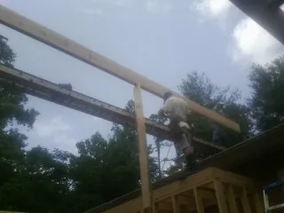 Carpenter setting a ridge beam over a new addition frame — Ice Dam Removal by Roofing Brothers in Tenino
